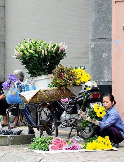 Flower vendor preparing for her day - good morning hanoi